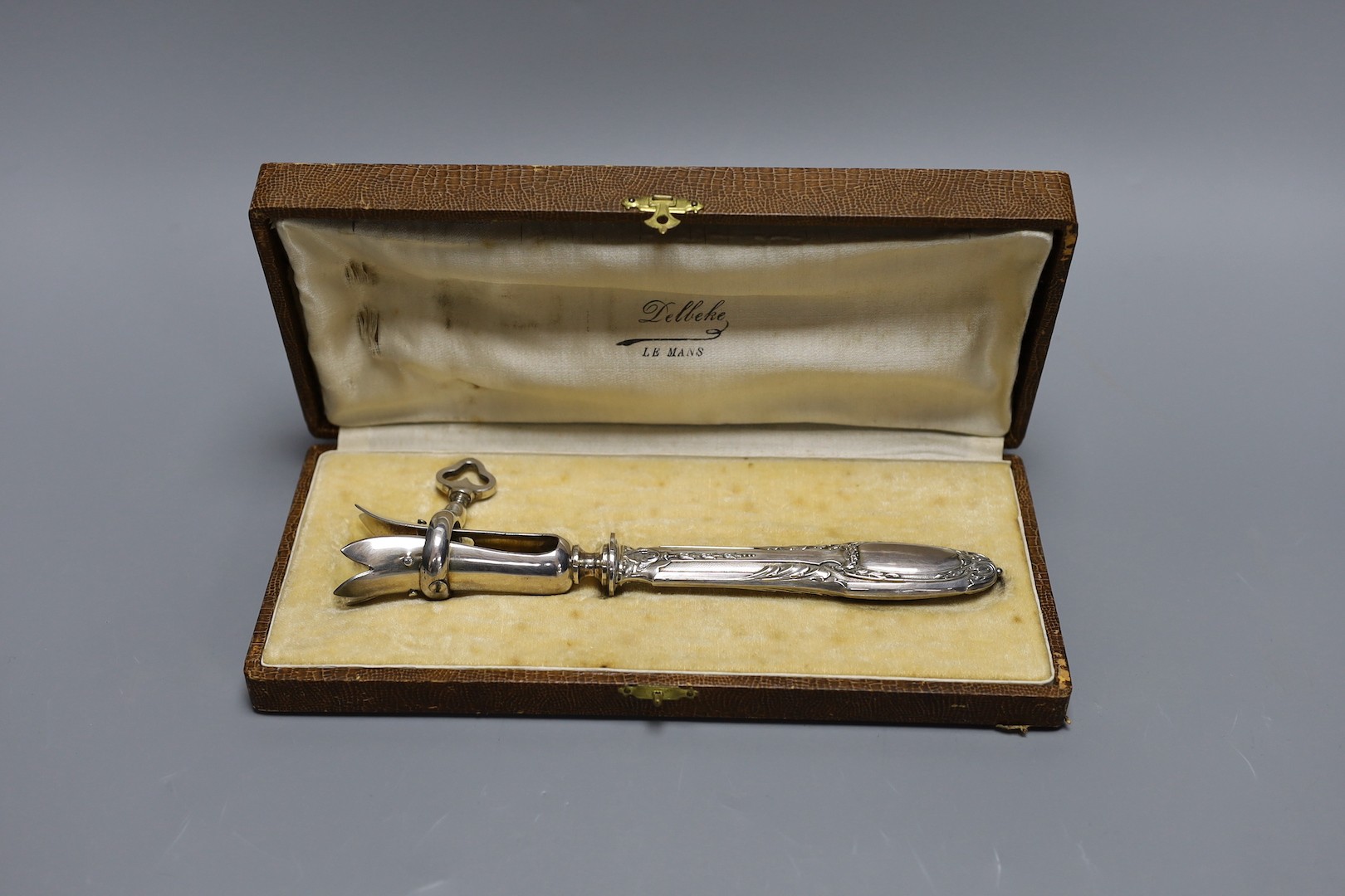 A silver plated ham clamp, cased, 21 cms long.